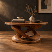 Round coffee table on a twisting interlaced loop base in a dark studio against a charcoal plaster wall