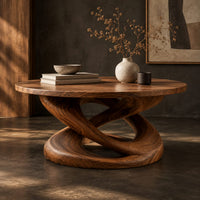 Corner detail of round coffee table on a twisting interlaced loop base beside wood, brass and linen samples