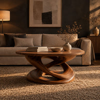 Round coffee table on a twisting interlaced loop base in a dark living room at golden hour