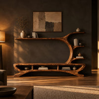 Low tv stand with a tree trunk rising into branch shelves in a dark living room at golden hour