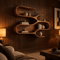 Sculptural wall shelf with three winding open tiers in an evening living room with walnut wall paneling