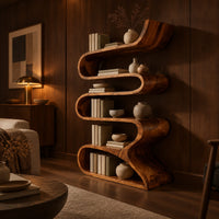 Serpentine bookshelf made from one folding ribbon of wood with open curved shelves in an evening living room with walnut wall paneling
