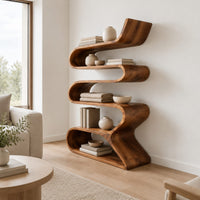 Serpentine bookshelf made from one folding ribbon of wood with open curved shelves in a Scandinavian living room with white walls