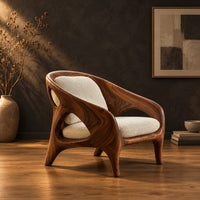 Shell back chair with oval side openings and splayed legs in a dark studio against a charcoal plaster wall