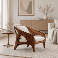 Shell back chair with oval side openings and splayed legs in a Scandinavian living room with white walls