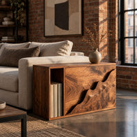 Boxy wood side table with a carved wave front panel and an open slot in an industrial loft living room with exposed brick