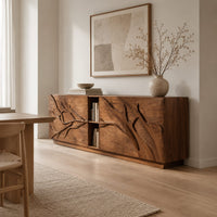 Low sideboard with carved branch doors and an open center bay in a Scandinavian dining room with white walls