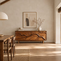 Low sideboard with a carved branch pattern across four front panels in a bright open plan dining room