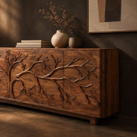 Corner detail of sideboard with a carved branching tree relief across four front panels beside wood, brass and linen samples