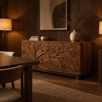 Sideboard with a carved branching tree relief across four front panels in an evening dining room with walnut wall paneling