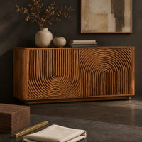 Corner detail of sideboard with fluted arch carving and rounded ends beside wood, brass and linen samples