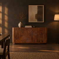 Sideboard with fluted arch carving and rounded ends in a dark dining room at golden hour