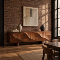 Sideboard on short block feet with flowing carved ridges across the front in an industrial loft dining room with exposed brick