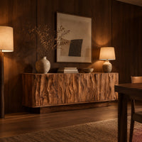 Low sideboard with four tall doors carved in a rippled flowing pattern in an evening dining room with walnut wall paneling
