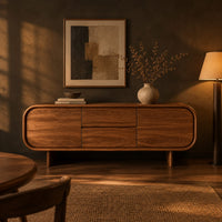 Long sideboard with soft oval ends and a four panel front in a dark dining room at golden hour
