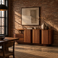 Sideboard with three grooved front panels and a lower block on one end in an industrial loft dining room with exposed brick