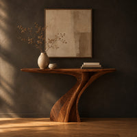 Console table on a single sculpted pedestal that twists up to the top in a dark studio against a charcoal plaster wall