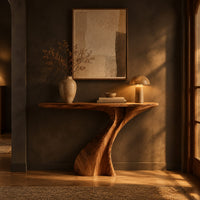 Console table on a single sculpted pedestal that twists up to the top in a dark entryway at golden hour