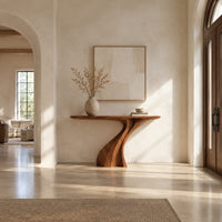 Console table on a single sculpted pedestal that twists up to the top in a bright open plan entryway