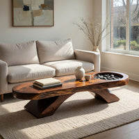 Long dark slab coffee table with a carved bowl in an open plan space in daylight
