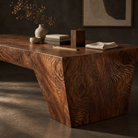 Corner detail of rectangular slab dining table with tapered carved end panels beside wood, brass and linen samples