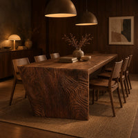 Rectangular slab dining table with tapered carved end panels in an evening dining room with walnut wall paneling