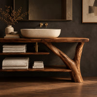 Corner detail of slab top bathroom vanity on a branch leg with two open shelves beside wood, brass and linen samples