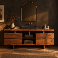 Slab top bathroom vanity with two drawer stacks and an open towel shelf in a dark bathroom at golden hour