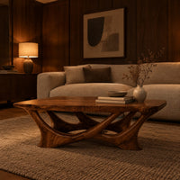 Slab top coffee table on a branching base of crossing curved arms in an evening living room with walnut wall paneling