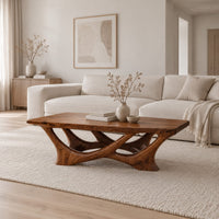 Slab top coffee table on a branching base of crossing curved arms in a Scandinavian living room with white walls