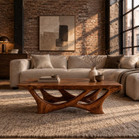 Slab top coffee table on a branching base of crossing curved arms in an industrial loft living room with exposed brick
