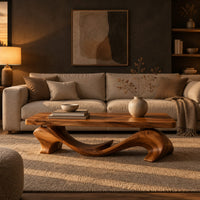 Slab top coffee table on a swooping wave shaped base in a dark living room at golden hour