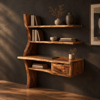 Wooden desk with a slab top, wavy side upright, two shelves and a drawer, three-quarter view showing the grain