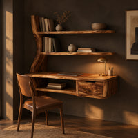 Wooden desk with a slab top, wavy side upright, two shelves and a drawer in a dark home office at golden hour