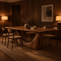 Rectangular dining table with a thick top on one deep crescent pedestal in an evening dining room with walnut wall paneling