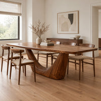 Rectangular dining table with a thick top on one deep crescent pedestal in a Scandinavian dining room with white walls