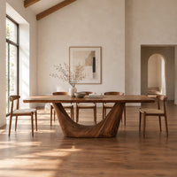 Rectangular dining table with a thick top on one deep crescent pedestal in a bright open plan dining room