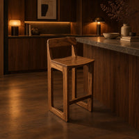 Bar stool with a low back, scooped seat and sled style legs in an evening kitchen with walnut wall paneling