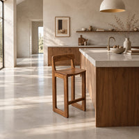 Bar stool with a low back, scooped seat and sled style legs in a bright open plan kitchen