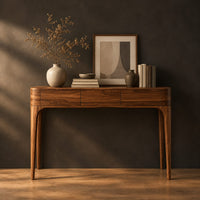 Slim console table with three front panels and tapered legs in a dark studio against a charcoal plaster wall