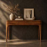 Corner detail of slim console table with three front panels and tapered legs beside wood, brass and linen samples