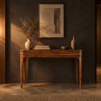 Slim console table with three front panels and tapered legs in a dark entryway at golden hour