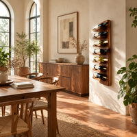 Slim vertical wine rack with seven angled cradles on a tall wooden board in a bright dining room with arched windows and plants