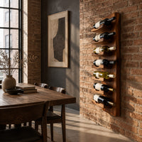 Slim vertical wine rack with seven angled cradles on a tall wooden board in an industrial loft dining room with exposed brick