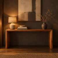 Slim waterfall console table with a smooth top and two wide slab legs in a dark entryway at golden hour