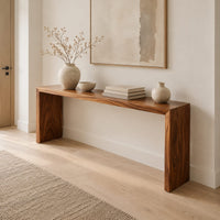 Slim waterfall console table with a smooth top and two wide slab legs in a Scandinavian entryway with white walls