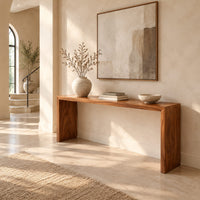 Slim waterfall console table with a smooth top and two wide slab legs in a bright open plan entryway