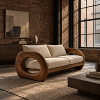 Wood sofa with open ring arms and two wide seat cushions in an industrial loft living room with exposed brick