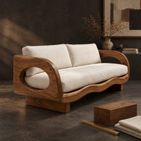 Corner detail of sofa with oval arm openings, a wavy wooden frame and pale seat cushions beside wood, brass and linen samples