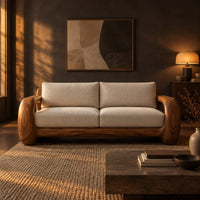 Sofa with thick open loop wooden arms and two seat cushions in a dark living room at golden hour